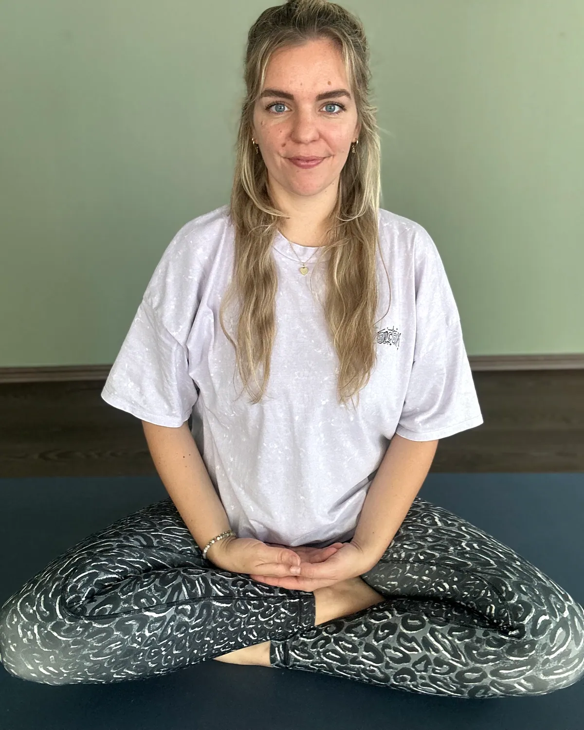 Nasti im Lotussitz vor salbeigrüner Wand, Yogalehrerin in Arnstadt